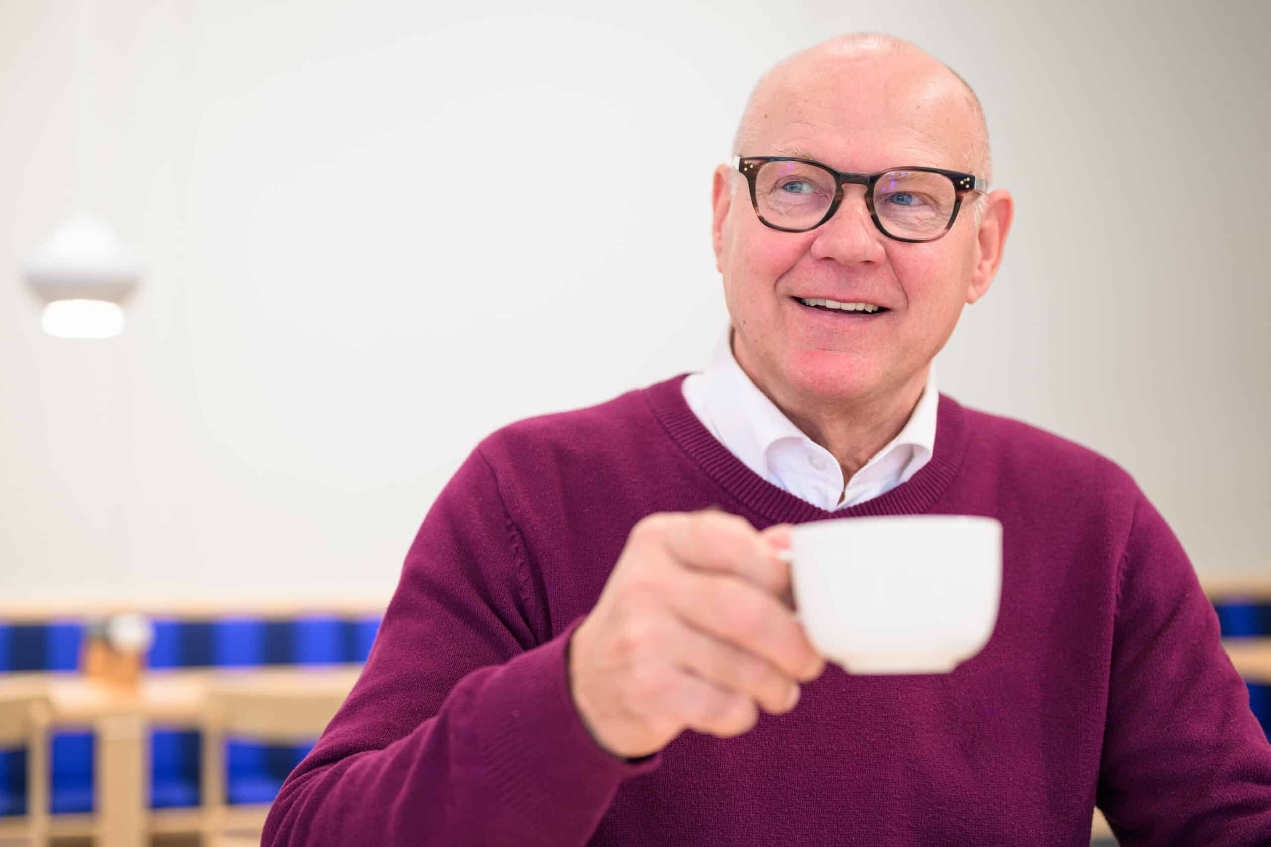 Mann mit Teetasse probiert verschiedene Mittel, um seinen Durchfall zu behandeln.